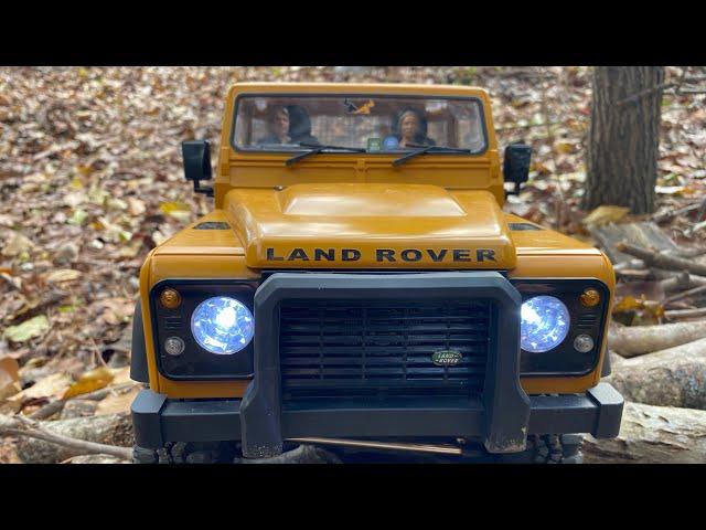 MN999 Land Rover out in the woods driving through and over the thick fall leaves and brush