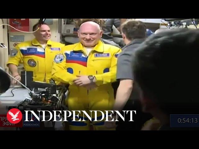 Russian cosmonauts arrive at the ISS wearing Ukrainian flag colours