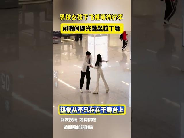 男孩女孩下飞机等待行李 闲暇间即兴跳起拉丁舞 网友：热爱从不只存在于舞台上