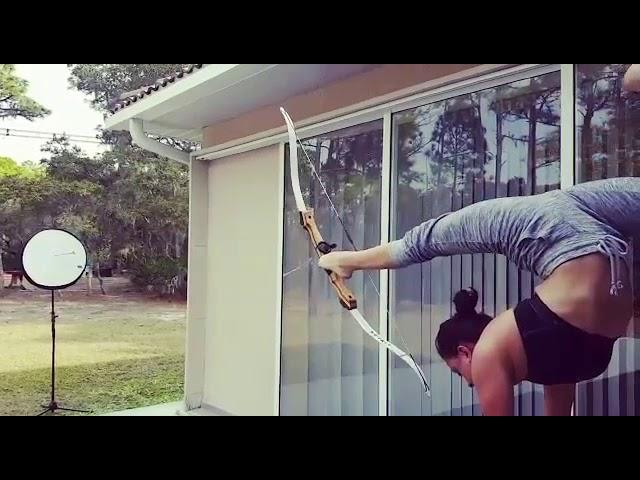 Woman Shoots Bow With Feet While Performing Handstand - 985714