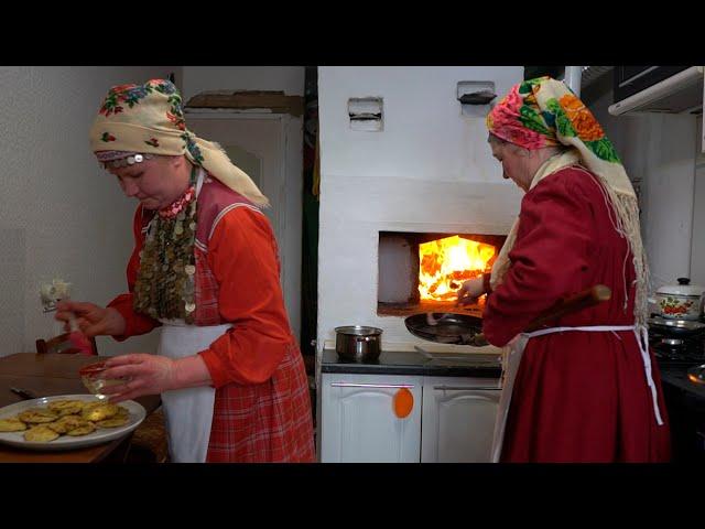 Two UDMURT hostesses preparing a viburnum pie - SHANYAN' in a wood oven. Russian cultures cuisine