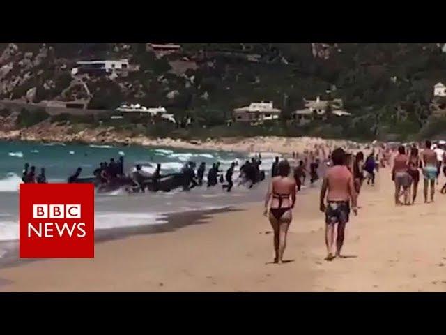 A boat full of migrants lands at a popular tourist beach in southern Spain - BBC News