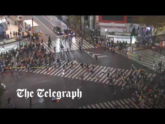 Japanese fans run across Tokyo's Shibuya crossing in celebration of World Cup win