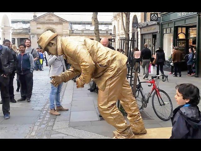 Golden man London street performer, floating and levitating trick Covent Gardens