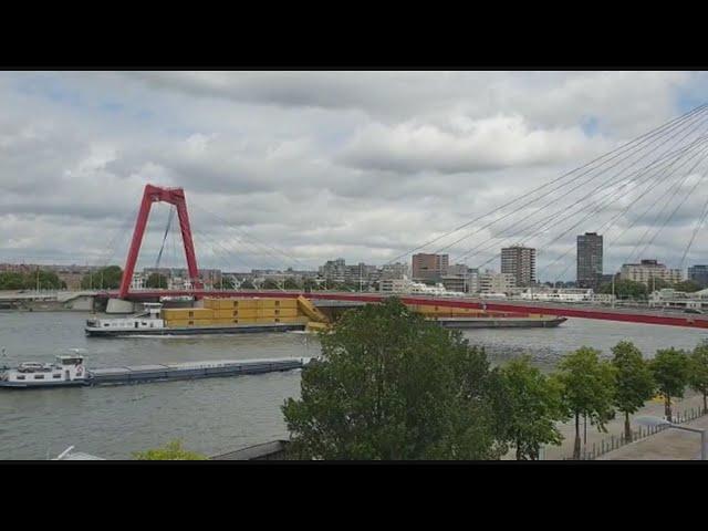 Te hoog beladen binnenvaartschip vaart tegen Willemsbrug; containers in het water