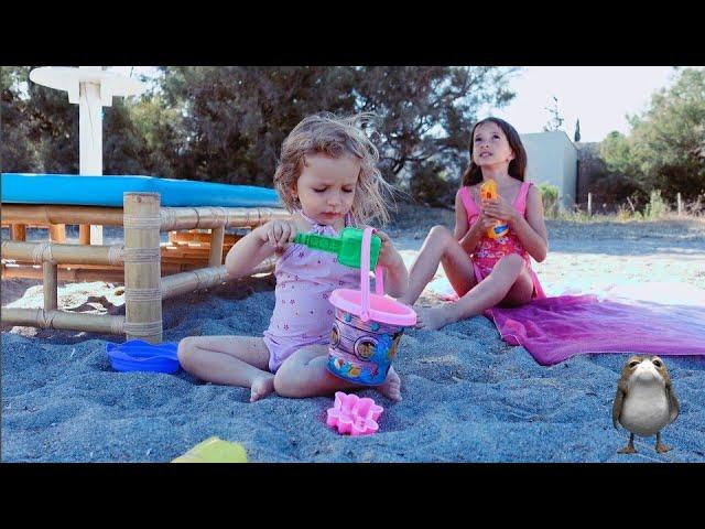 Anisia and Amelia playing on the beach with sand and other kids toys