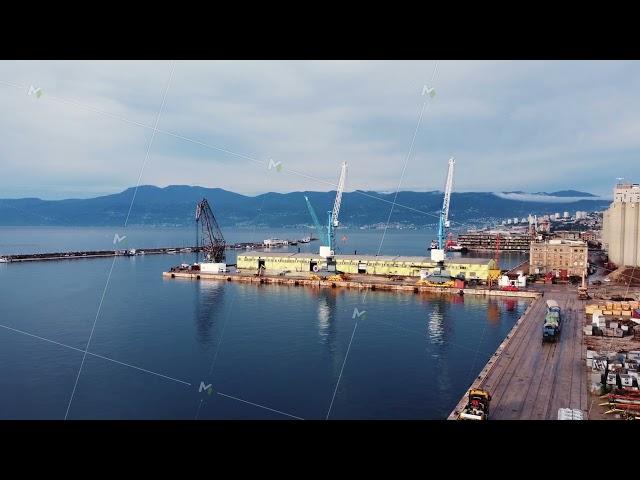 Drone view of the cargo seaport and huge port cranes. Handling dock for ships, dry cargo ships