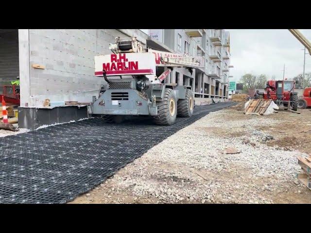 Rough terrain crane driving over GEOTERRA GTO Construction Mats at apartment complex