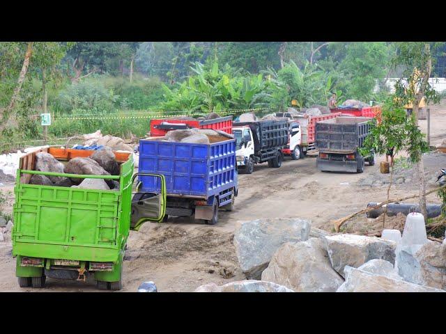 Dump Trucks queue to unload rocks with excavators