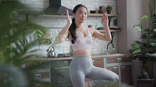 Healthy asian yoga woman doing yoga in tree pose at home