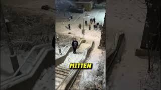 Schüler rollen riesige Schneekugel eine Treppe hinunter 