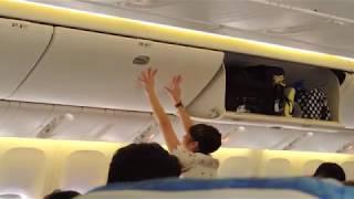 Cathay Pacific Cabin Crew Member Secures Luggage in Overhead Bins