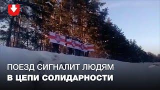 Поезд сигналит людям, которые стоят в цепи солидарности возле железной дороги