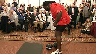 Mark Henry attempts to lift the legendary Thomas Inch Dumbbell with one hand (WWE Network)