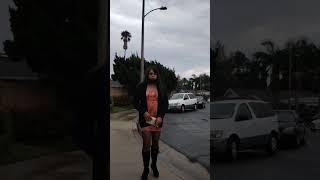 crossdresser Avery in public orange minidress and boots rainy day