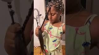 Little girl braids her hair for the first time