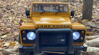 MN999 Land Rover out in the woods driving through and over the thick fall leaves and brush