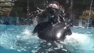 Female Person is Wearing Latex Catsuit and Gasmask in Pool