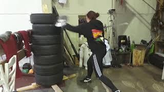 Buhurt training basic kicks and hitting tower of tires with sword and shield