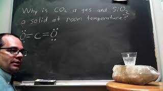 Why is CO2 a gas and SiO2 a solid at room temperature?