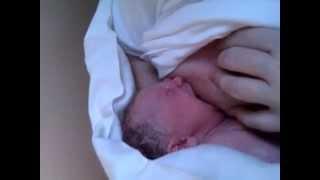 Newborn baby breastfeeding for the very first time in its life.