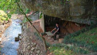 I built a warm shelter under a large rock in the rain forest and cooked