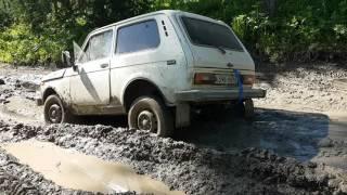 Нива, с заваренным редуктором заднего моста, выползает из грязи.