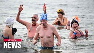 German and Italian swimmers enjoy cold water with traditional New Year's dips