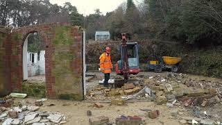 Demolishing more walls and stacking salvaged bricks