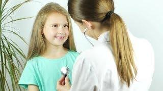 A Female Doctor Hearing Heartbeat of Cute Young Girl. Review of a Child in a Pediatrician | Stock