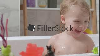 Little girl playing in the bath and splashing water