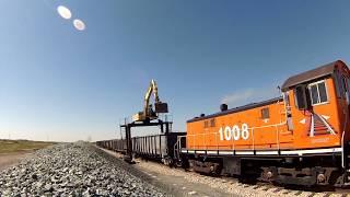 Straddle Excavator Unloading Gravel Railcars