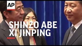 Japan's Prime Minister Shinzo Abe and Chinese President Xi Jinping hold a frosty handshake at APEC s