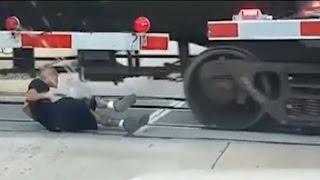 Man rolls under moving freight train