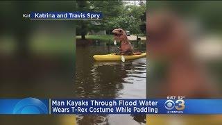 Man Kayaks Through Flooded Community Wearing T-Rex Costume