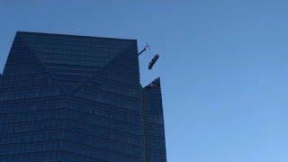 Window cleaners swing violently on out of control lift atop skyscraper