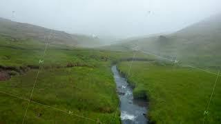 Aerial view of Reykjadalur valley in foggy day with hot spring pool steaming fumarole in Iceland