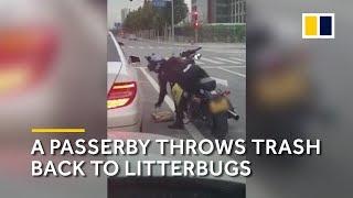A passerby throws trash back into a litterbug’s car