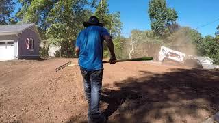 Bobcat Rockhound cleaning up a yard, removing rocks and roots.