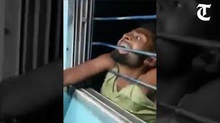 Mobile thief left hanging outside moving train after passengers pull him through window bars