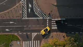 Aerial birds eye overhead top down view of yellow convertible car turning on main road. Late