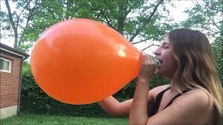 Belle blowing big balloons in backyard