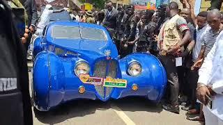 Cheddar (Nana Kwame Bediako) arrives in grand style with a Rolls Royce, among other luxury cars.