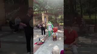 Mascot Frog Dances With Elderly Folk Band