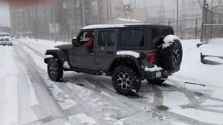 2018 Jeep JLU Rubicon on ice pulling a Semi out of a ditch