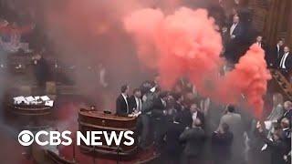 Serbian parliament erupts into chaos as smoke grenades, tear gas clash ensues