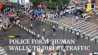 Police form ‘human walls’ to direct traffic in China