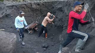 the process of searching for black sand, working together to separate black sand and rocks