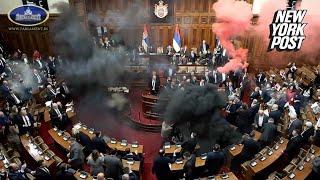 Chaos erupts in Serbian Parliament as lawmakers brawl and throw smoke bombs