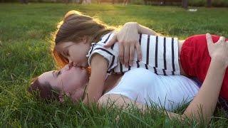 Mother and daughter lying on grass. Kiss